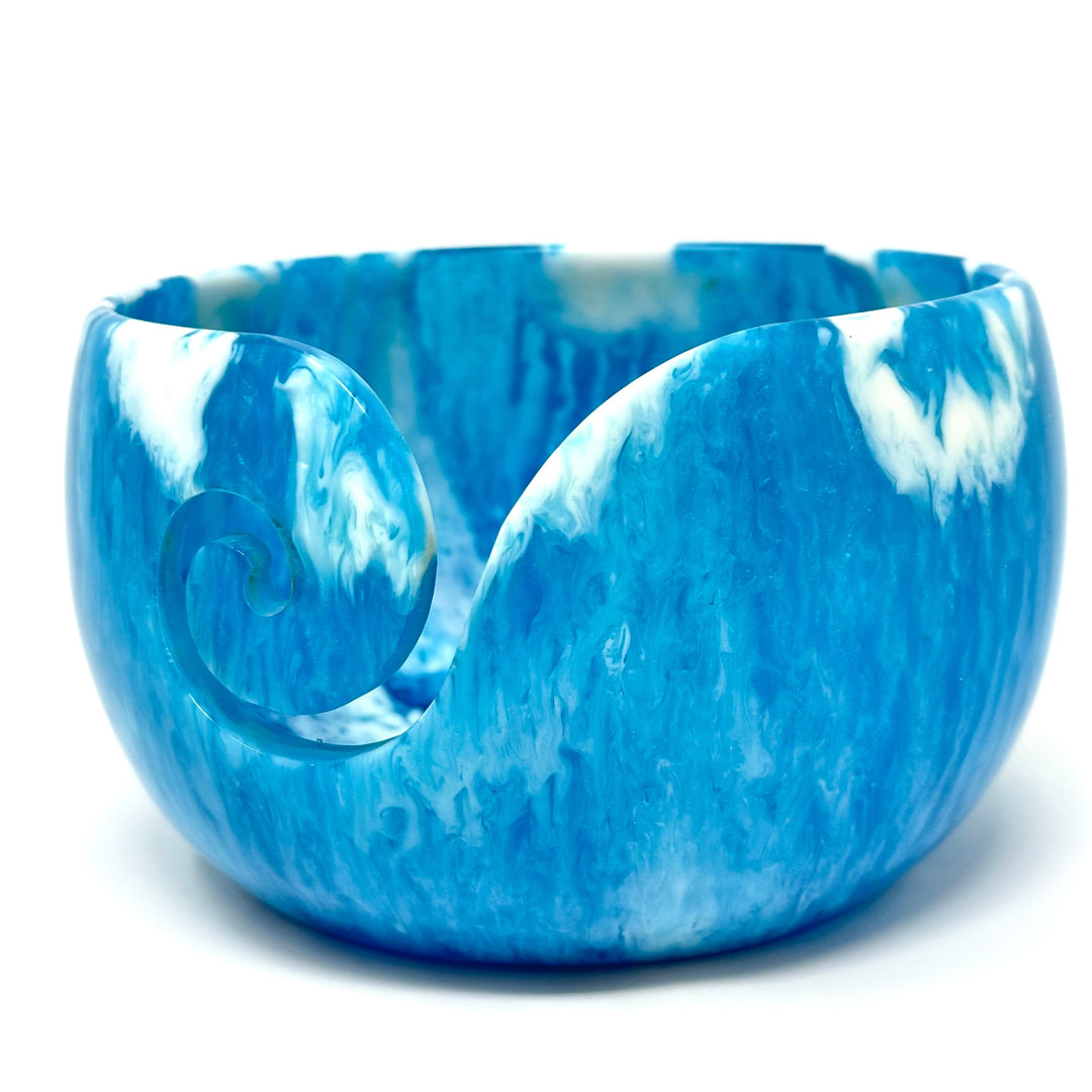Blue and white marbled yarn bowl with a carved swirl cutout.