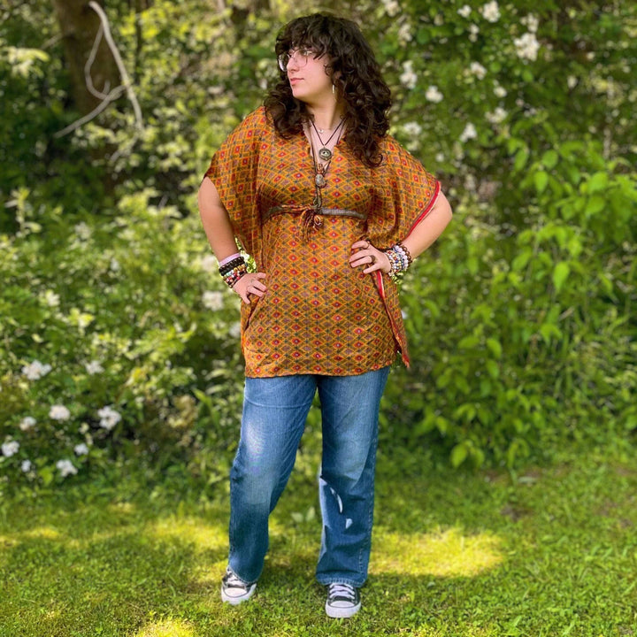 Woman standing in front of a forest wearing a aanya short kaftan