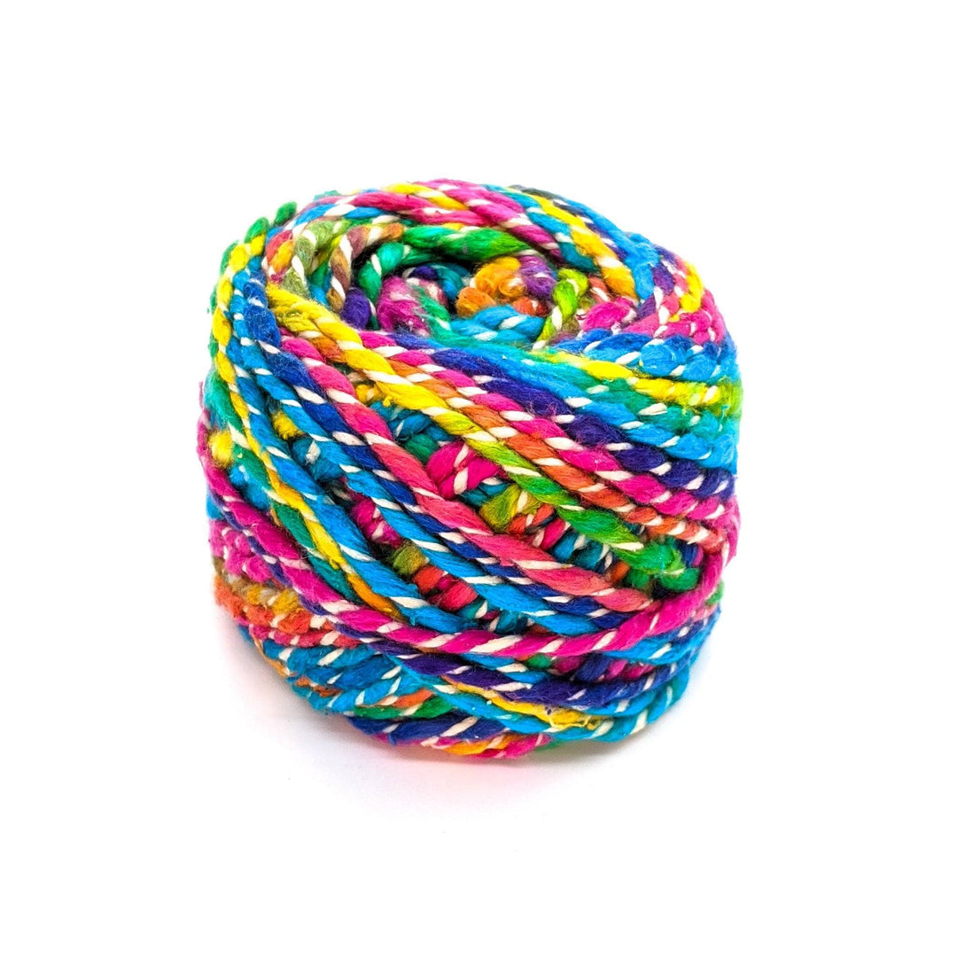 single cake of darn good fancy twist in white rainbow (rainbow and white marled) in front of a white background.