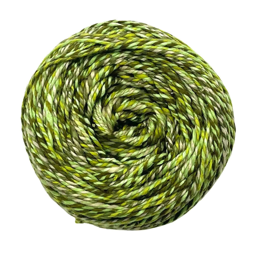 A skein of twisted green yarn in various shades, wound in a spiral shape.