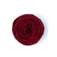 A neatly wound ball of dark red yarn on a white background.
