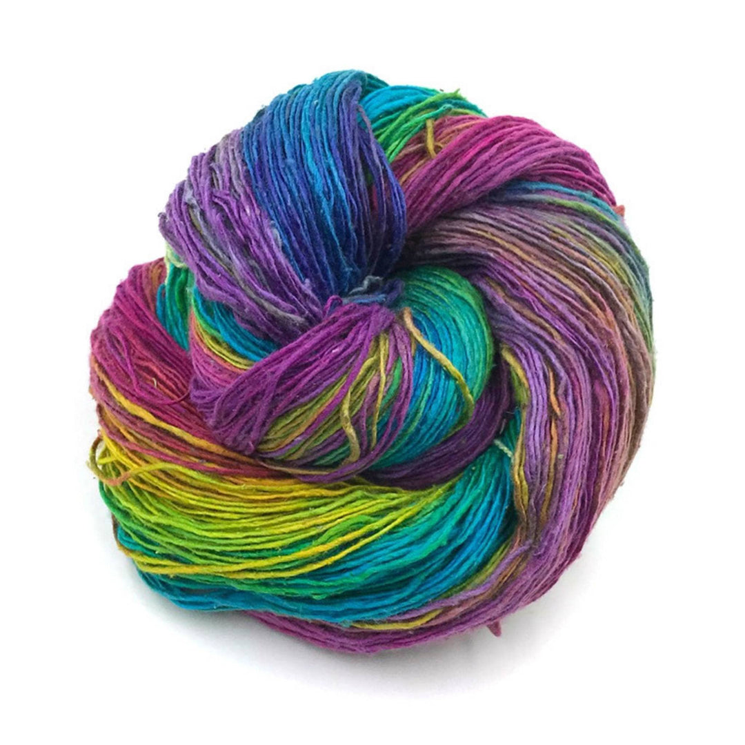 bright variegated rainbow lace weight silk yarn in front of a white background.