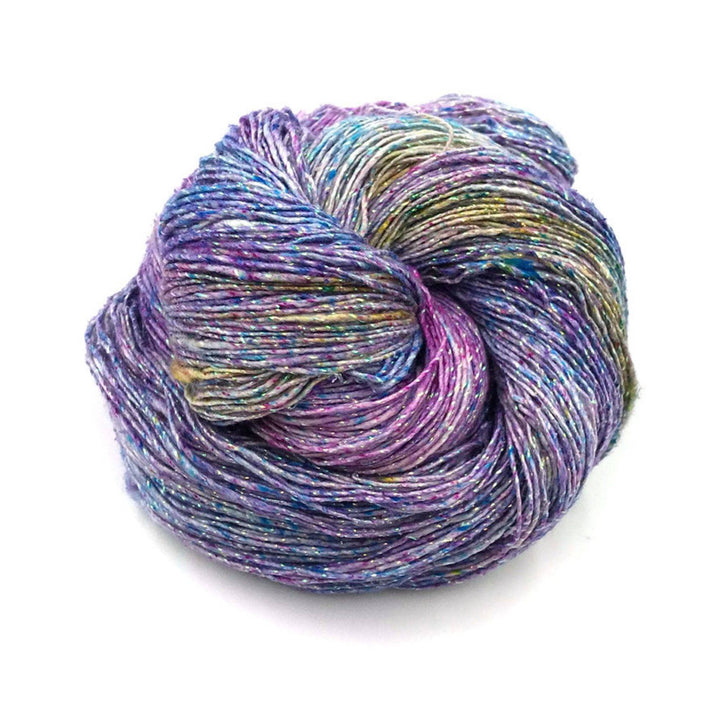 one skein of light fingering weight silk sparkle yarn in front of a white background.