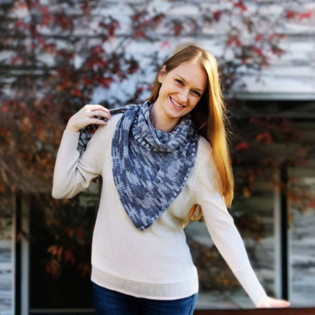 Woman wearing Andina Scarf in Date Night (grays) in front of fall foliage