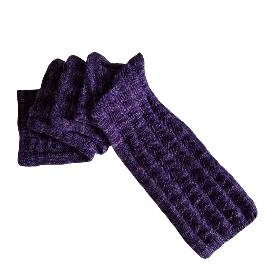 purple textured knit scarf folded and laid flat in front of a white background.