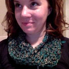 Photo of woman in black tee shirt and green knit cowl