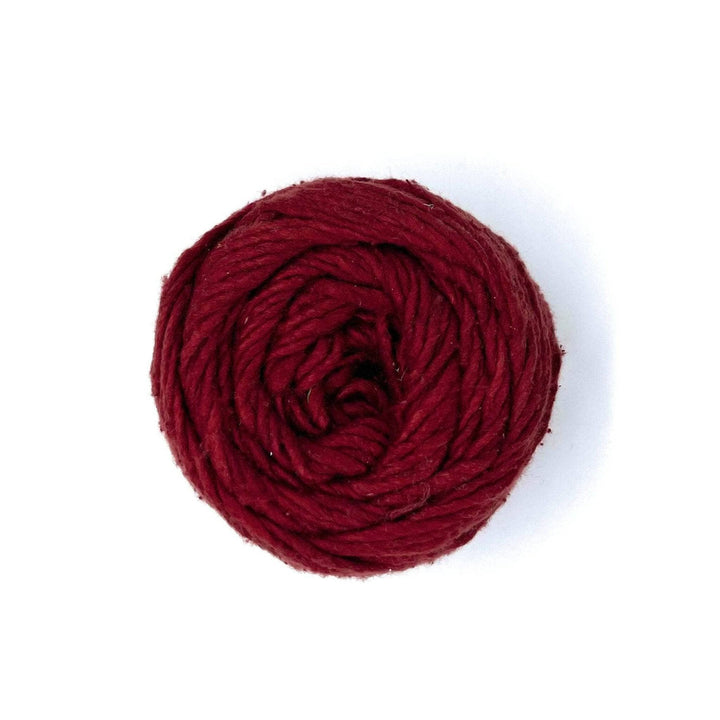An overhead view of a cake of worsted weight silk yarn in the color Marsala Wine. This yarn is burgundy. There is a strand of sparkle spun into this yarn