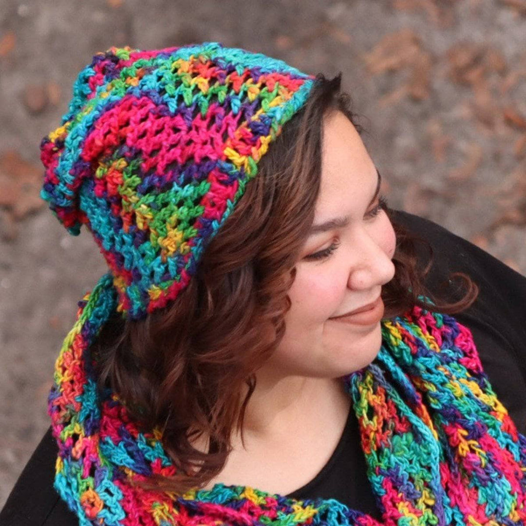 Close up of woman wearing a multicolored scarf and beanie set and a black t shirt