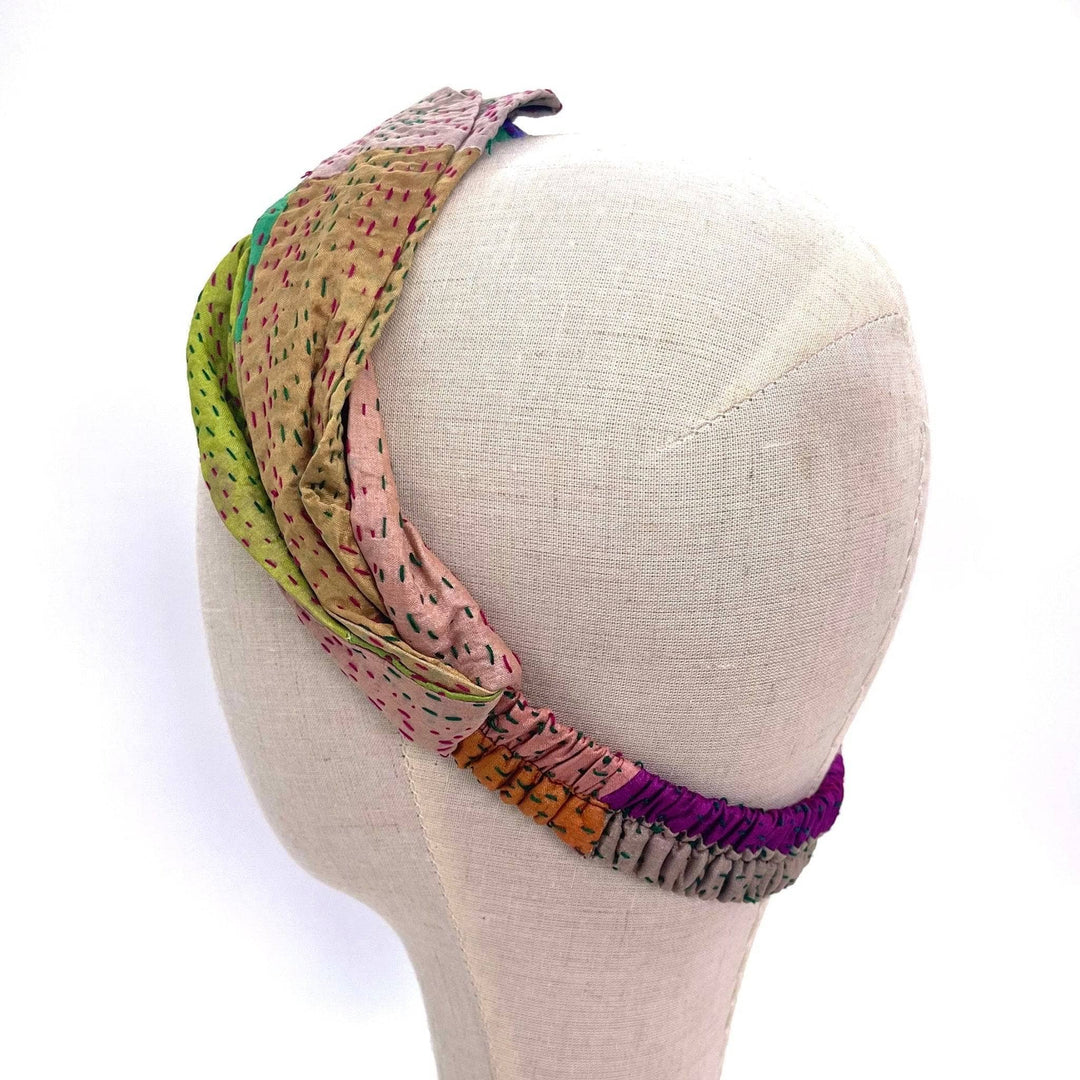 the back of a mannequin head, showing the adjustability of the kantha stitched headband.