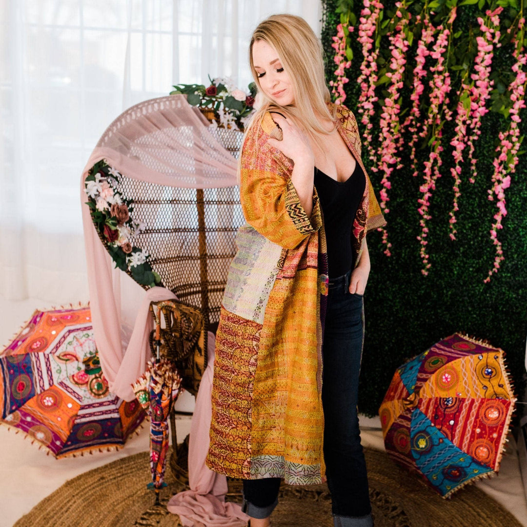 Model wearing one of a kind kantha jacket in front of a colorful background