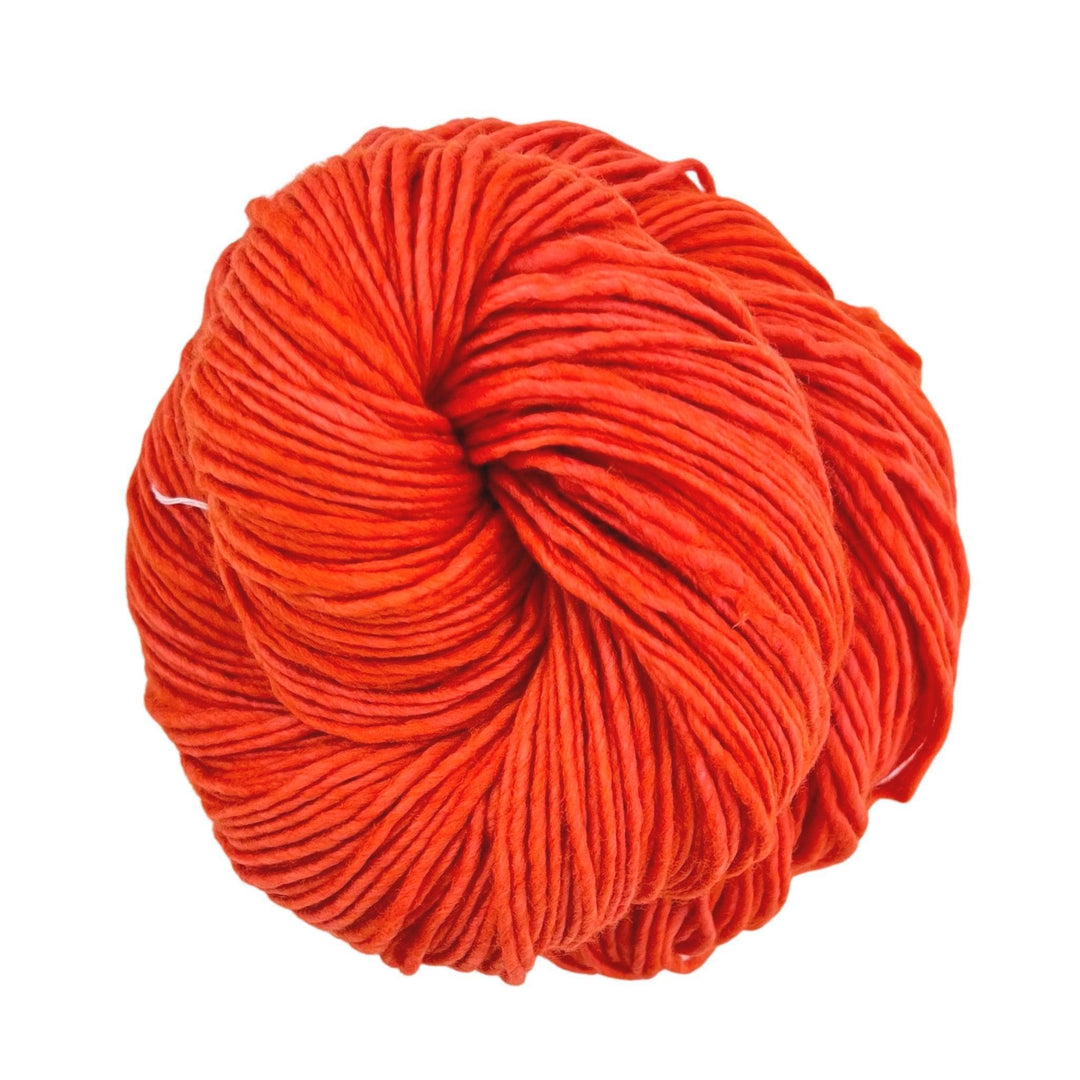 skein of vibrant orange single ply wool yarn in front of a white background.