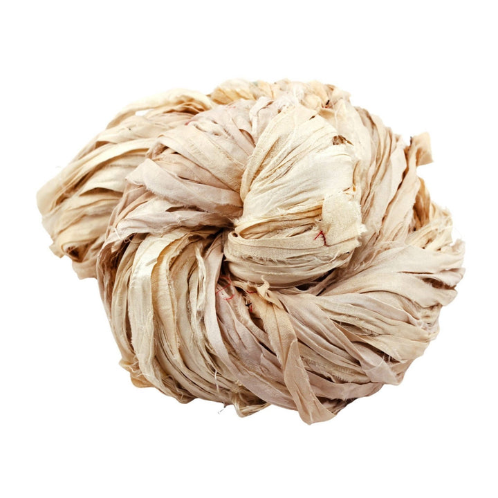 yarn made from off white reclaimed sari ribbon in front of a white background.