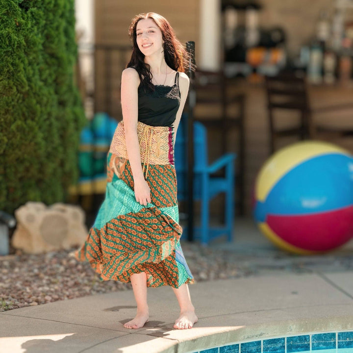 Girl posed by a pool, wears the sedona patchwork dress