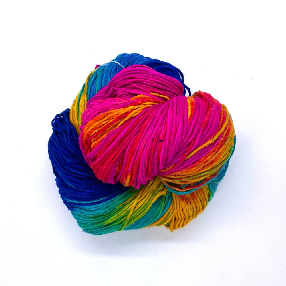 Navy blue, Light blue, Magenta, Green, and Yellow worsted weight yarn on a white background