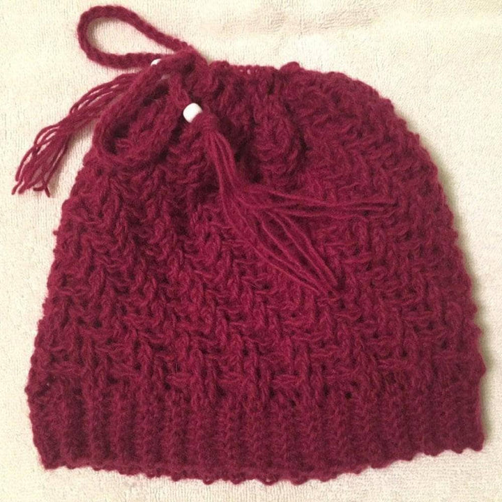 completed spiral hat in red in front of a beige background.