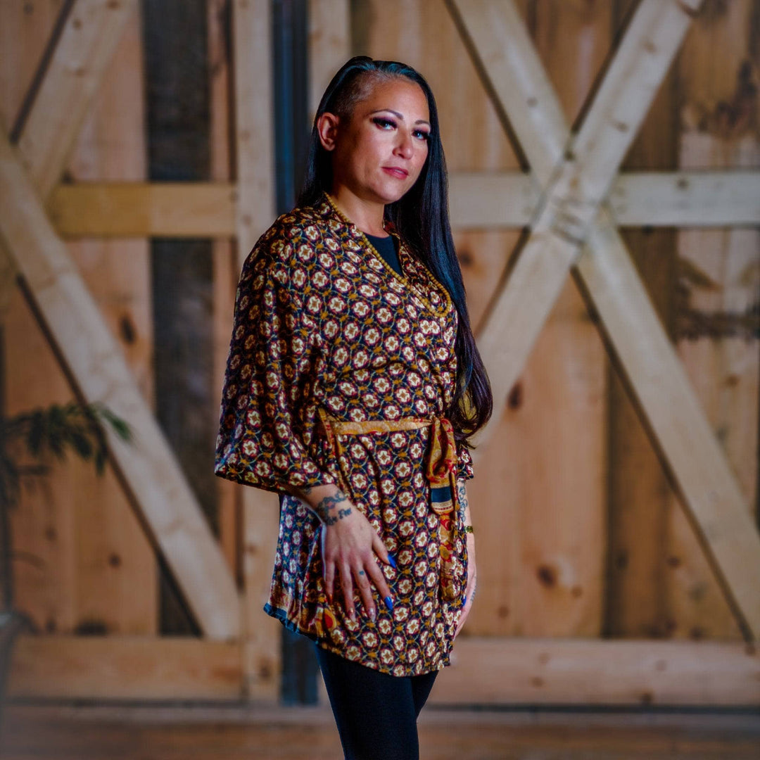 Model is standing in front of a wooden wall wearing a brown short charlotte chic short robe.