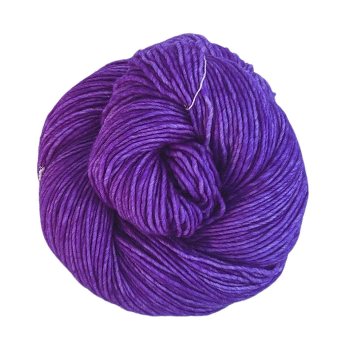 skein of single ply tonal purple wool malabrigo yarn in front of a white background.