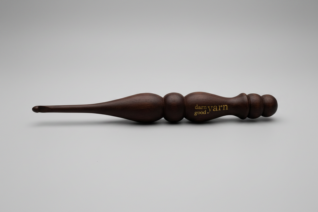 Brown wooden yarn swift on a white surface