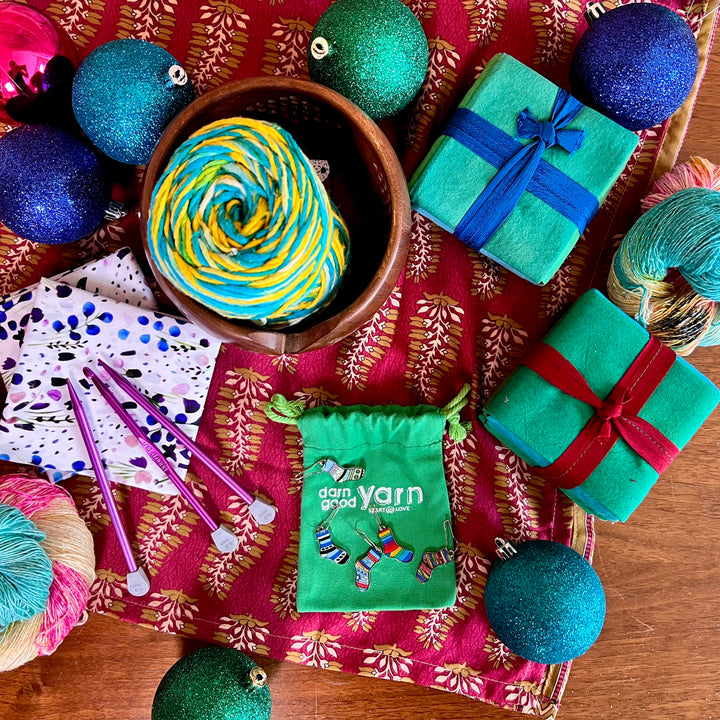 Colorful yarn ball and crochet accessories arranged on a festive background.