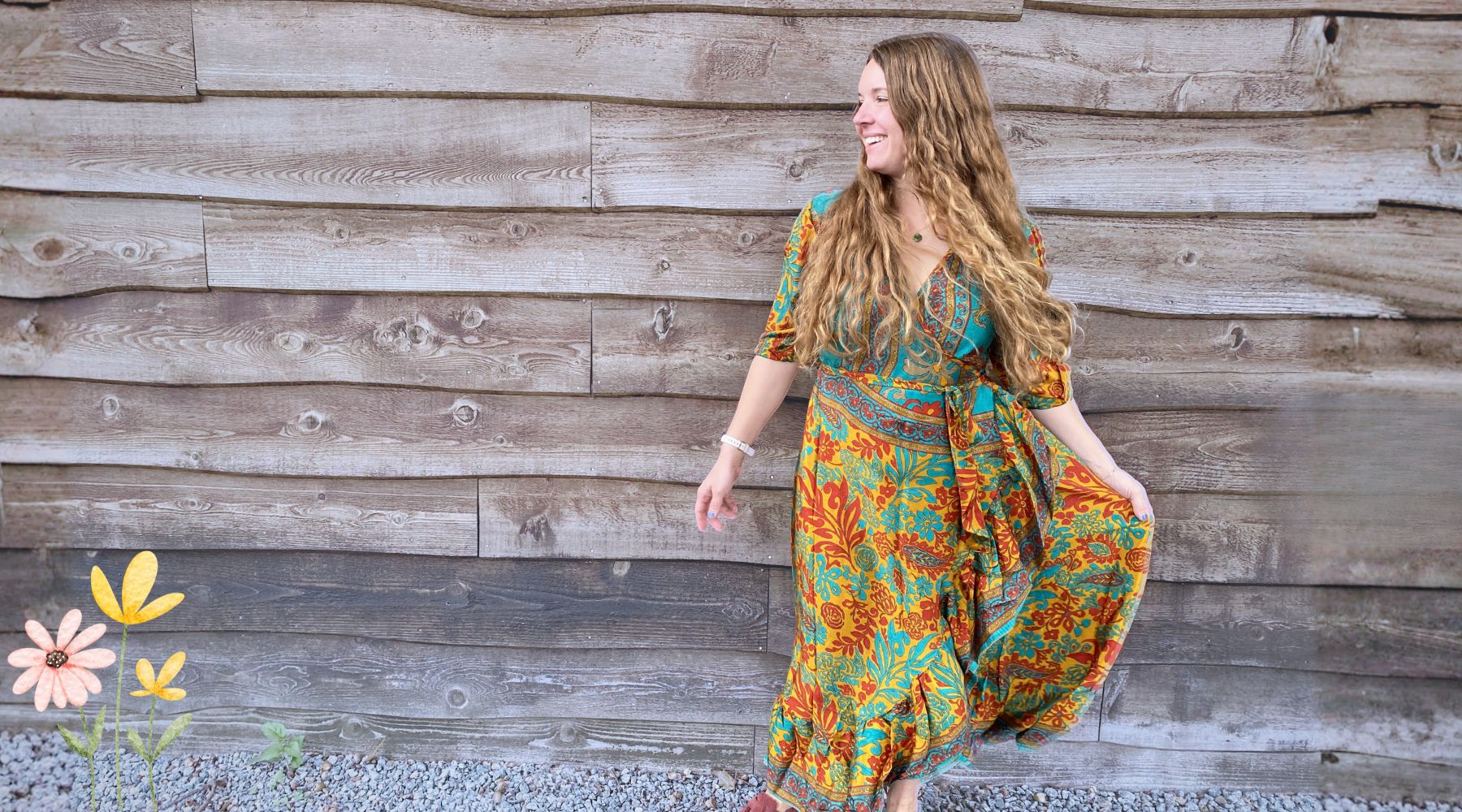 Woman in a floral dress standing against a wooden wall