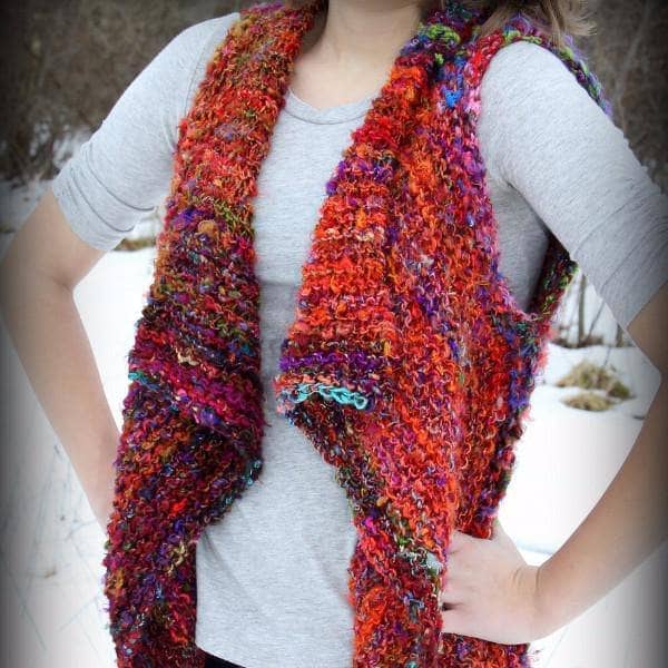 Woman wearing Adventure Cardi vest in multicolor standing in front of a snowy landscape