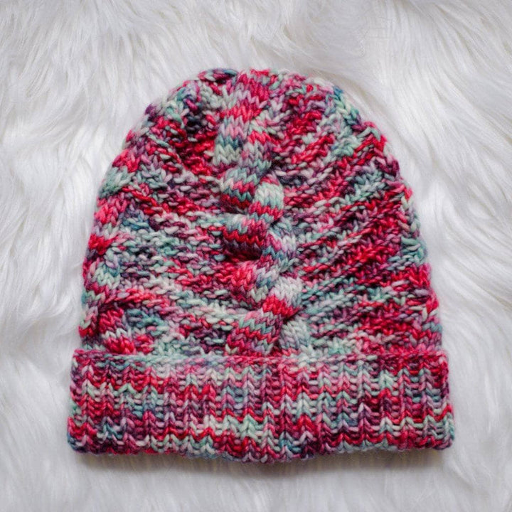Ash Cave Beanie in Benjamin (red and gray) on a white fur background