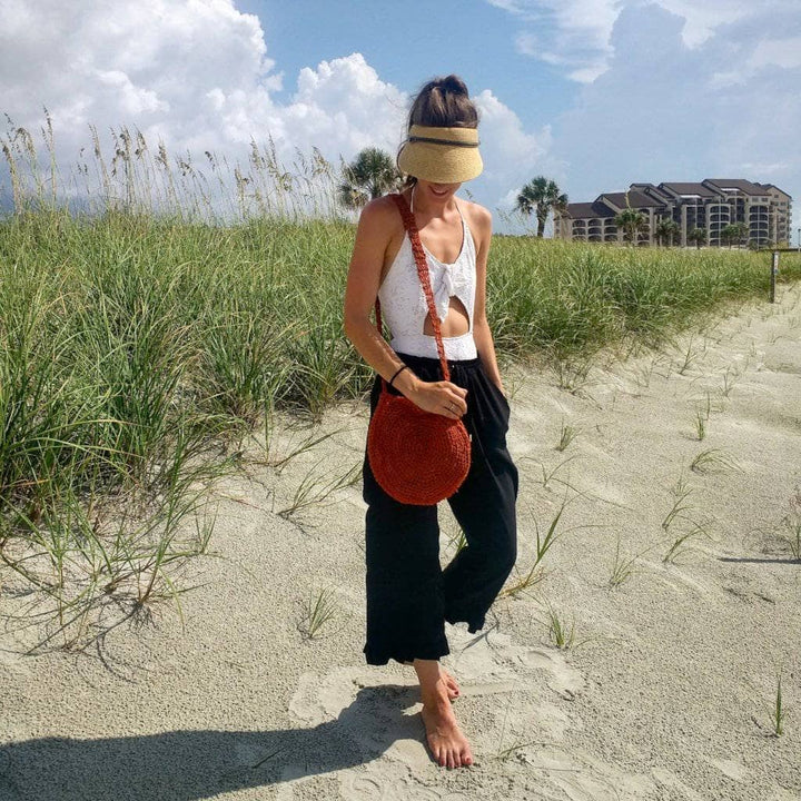 Woman wearing a Beach Day Bag Crochet shoulder bag while standing on a beach