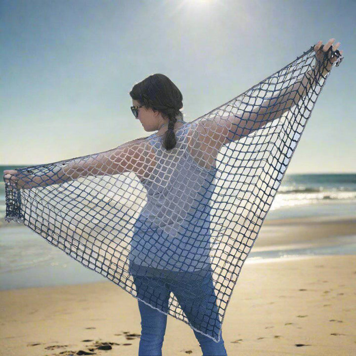 Woman holding a Blue Jay Triangle Scarf behind her back and standing in front of a white wall