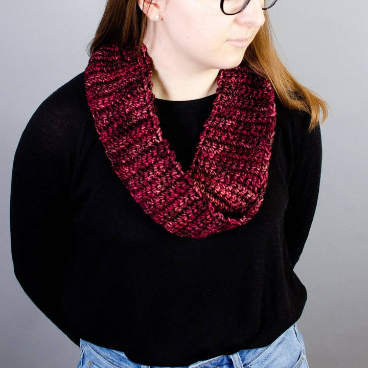 A women wearing a black shirt with a red infinity scarf around her neck 