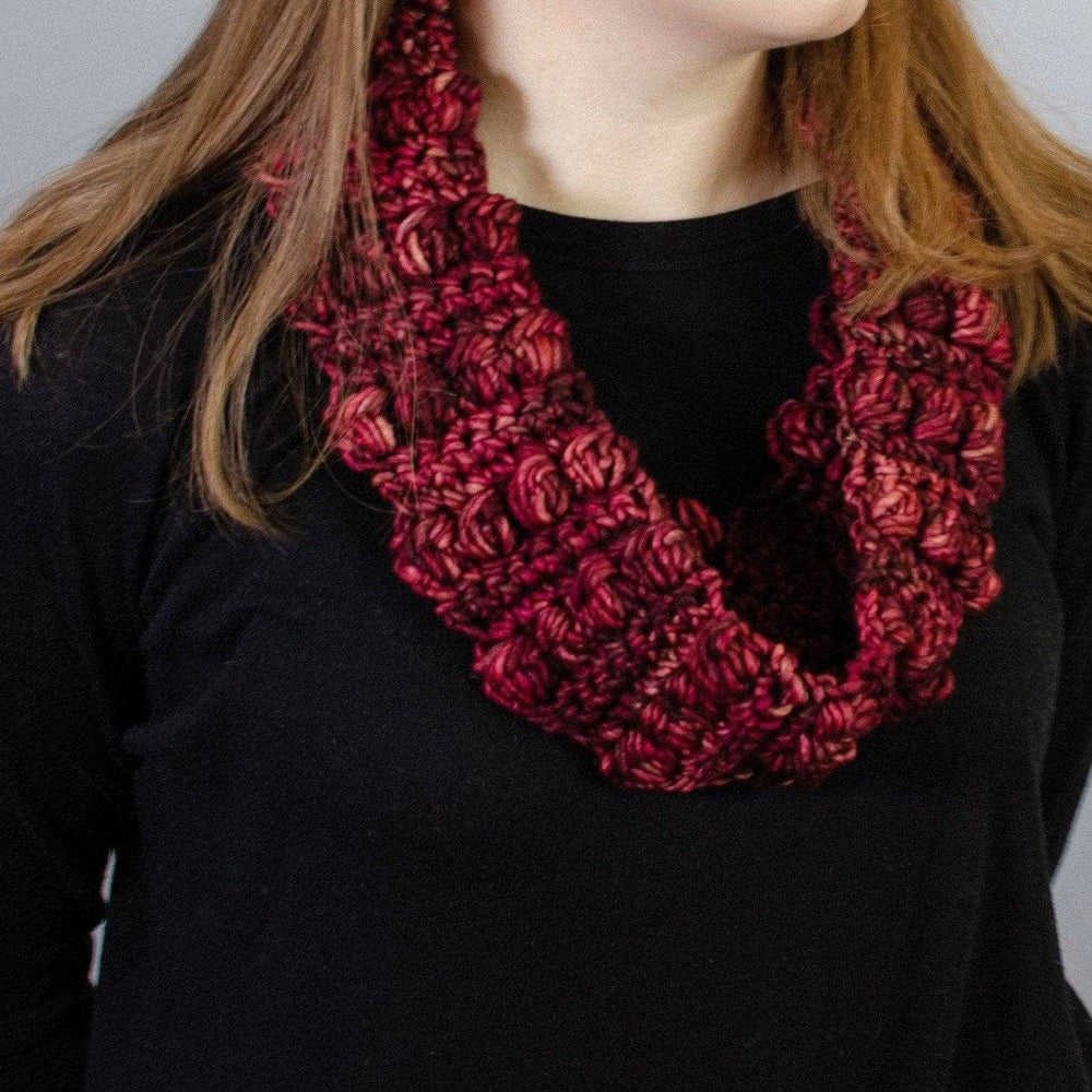 A women wearing a black shirt with a red infinity scarf around her neck 