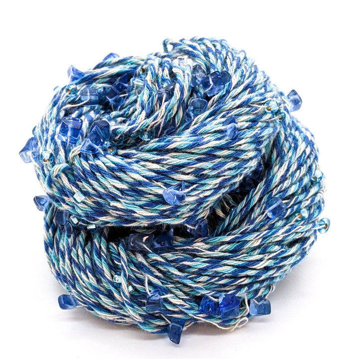 A coiled bundle of blue and white twisted rope with blue crystal decorations.