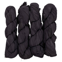 Four tightly twisted black fabric bundles displayed vertically on a white background.