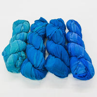 Five skeins of blue fabric yarn arranged in a row