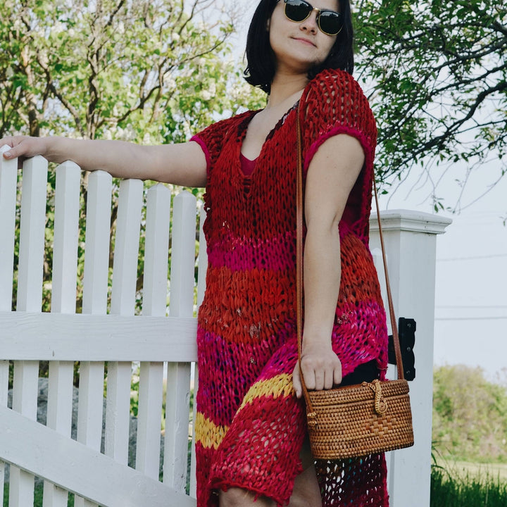 Model wearing chiffon summer layering top in front of a white picket fence.