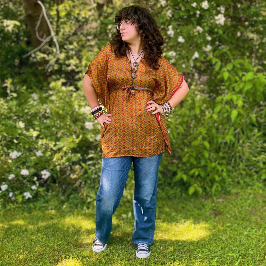 Woman standing in front of a forest wearing a aanya short kaftan