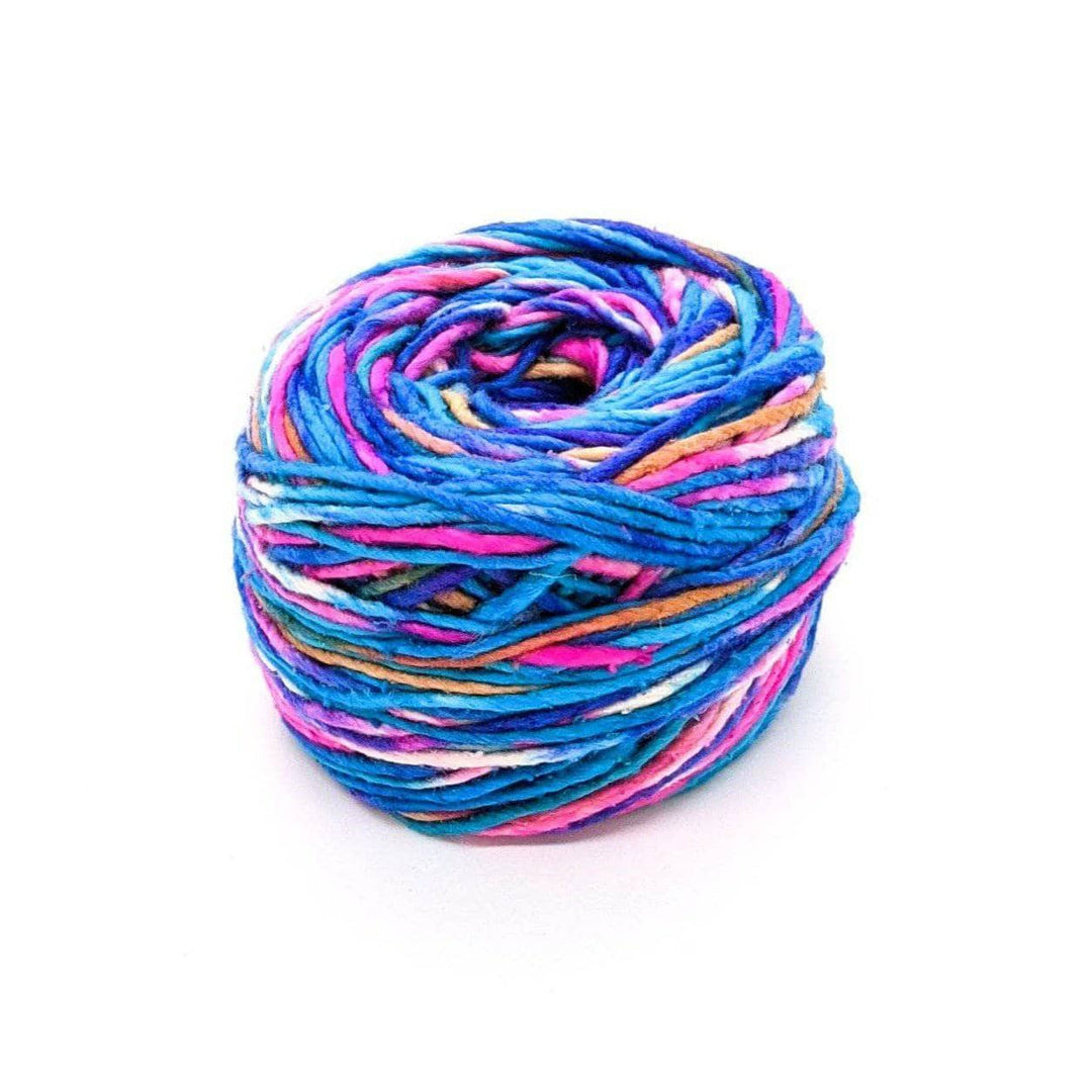 A cake of blue, pink, white, tan, and purple yarn on a white background