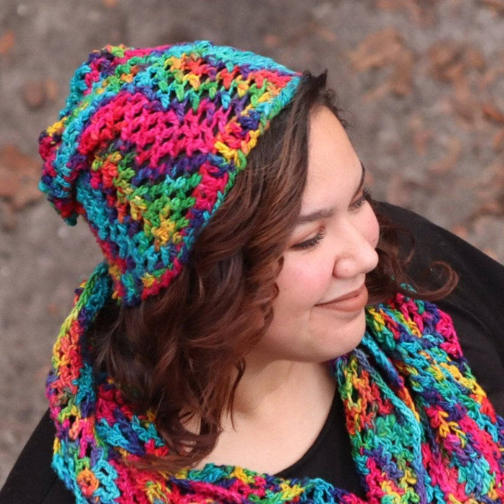 Close up of woman wearing a multicolored scarf and beanie set and a black t shirt