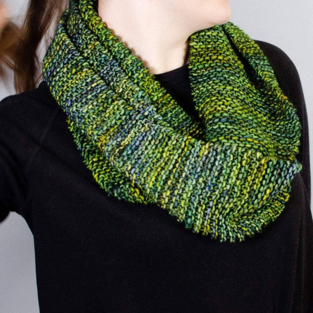 a women wearing a black shirt with jean wearing a green scarf