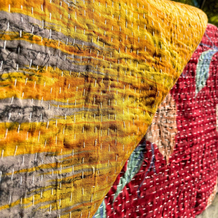 A close up of vintage kantha stitched quilts.