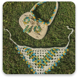 Handmade crochet bag and scarf in white, blue, and yellow tones.