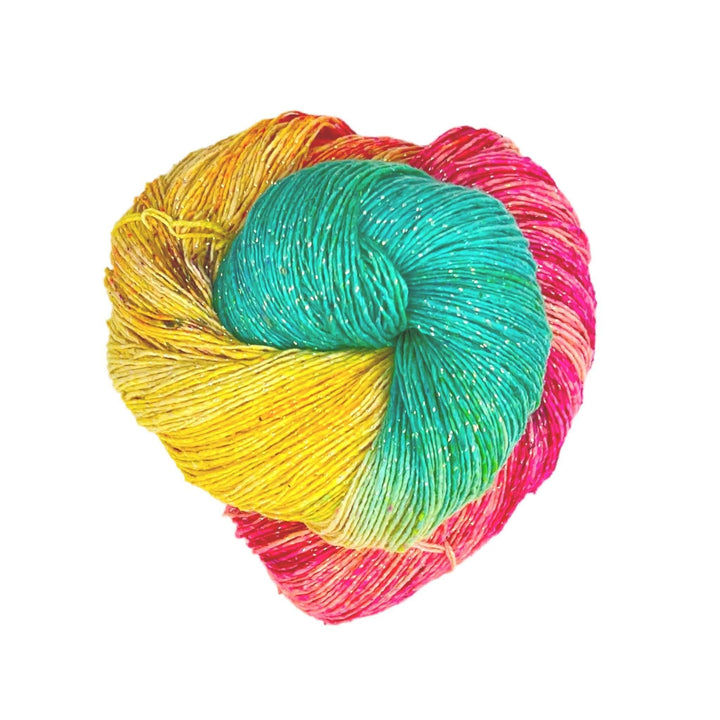 skein of sparkle pastel dreams recycled silk yarn in front of a white background. Lace weight variegated yellow, blue, pink with black speckles.