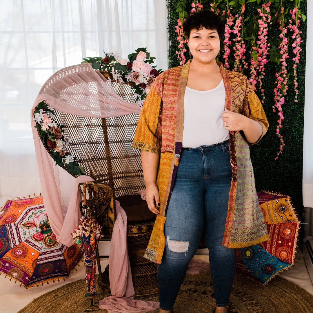 Model wearing one of a kind kantha jacket in front of a colorful background