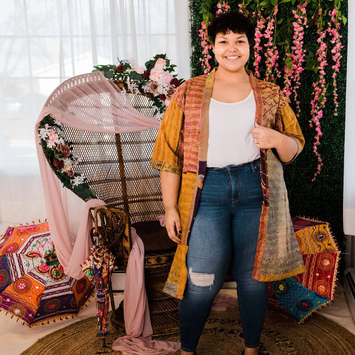 Model wearing one of a kind kantha jacket in front of a colorful background