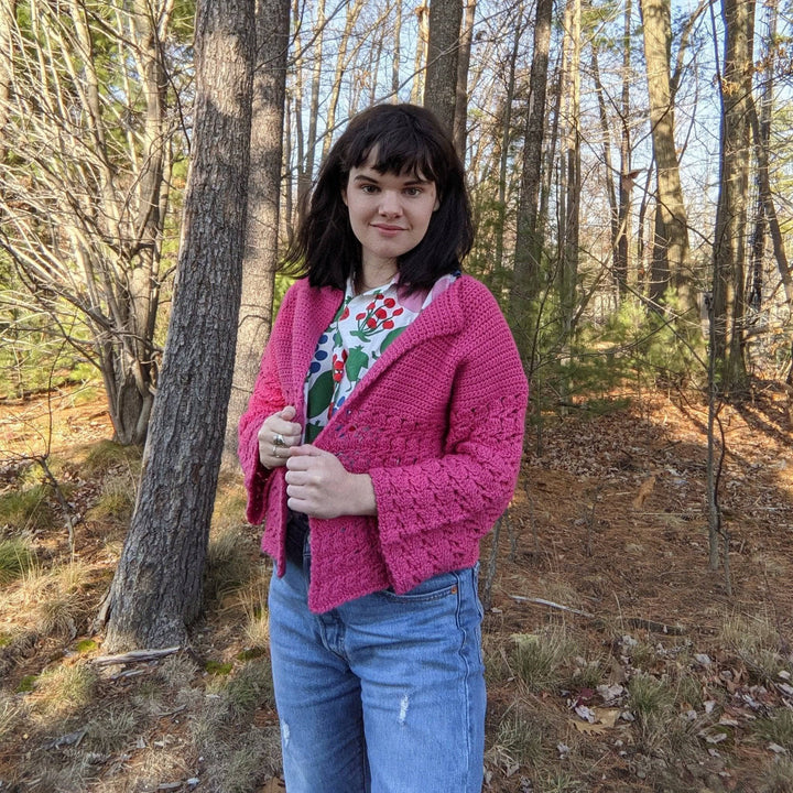 a person wearing a pink cardigan outside
