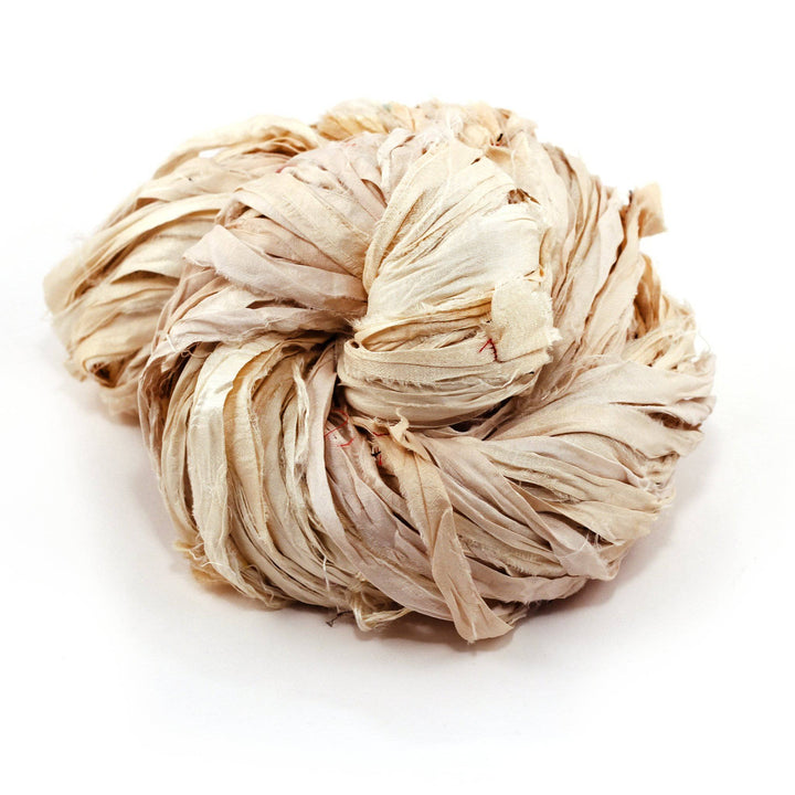 a skein of white ribbon yarn on a white background