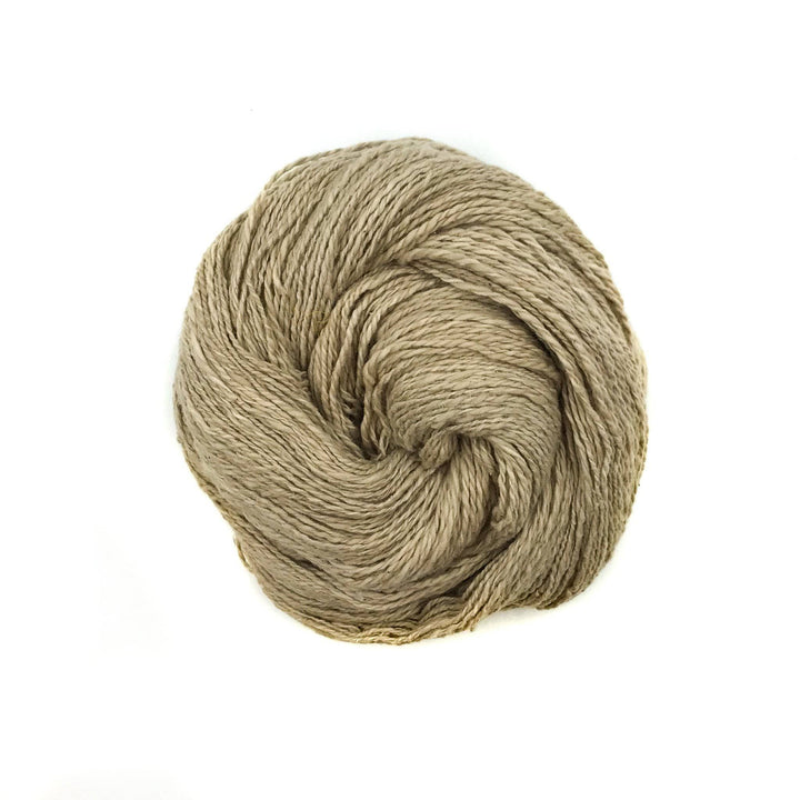 close up of yarn in the color fresh Mimosa Legume (beige) with a white background