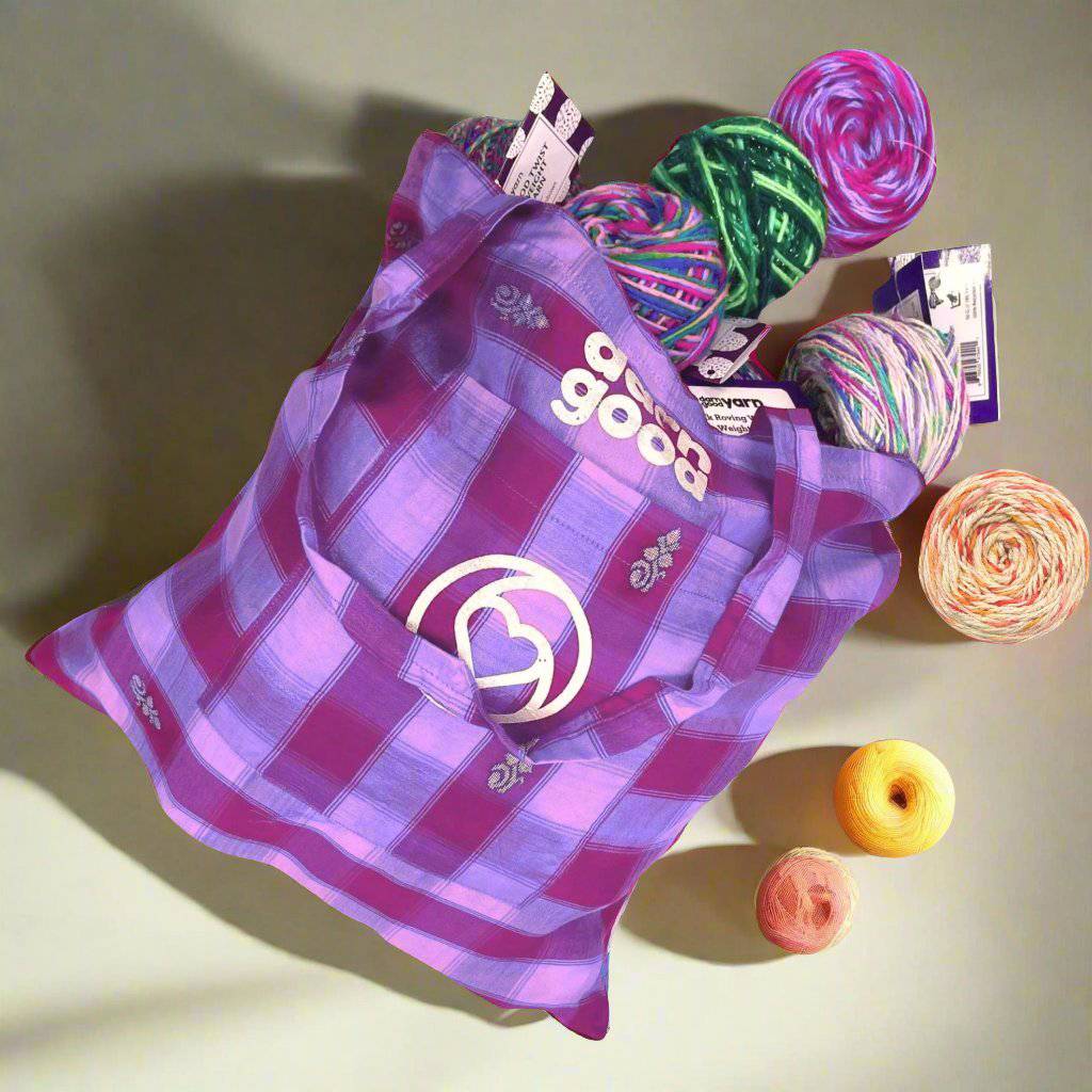 Sari Silk Tote laying on a white background. Theres a bunch of different yarns