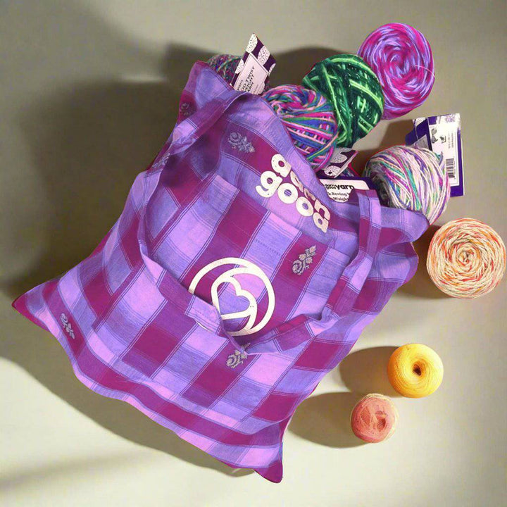 Sari Silk Tote laying on a white background. Theres a bunch of different yarns