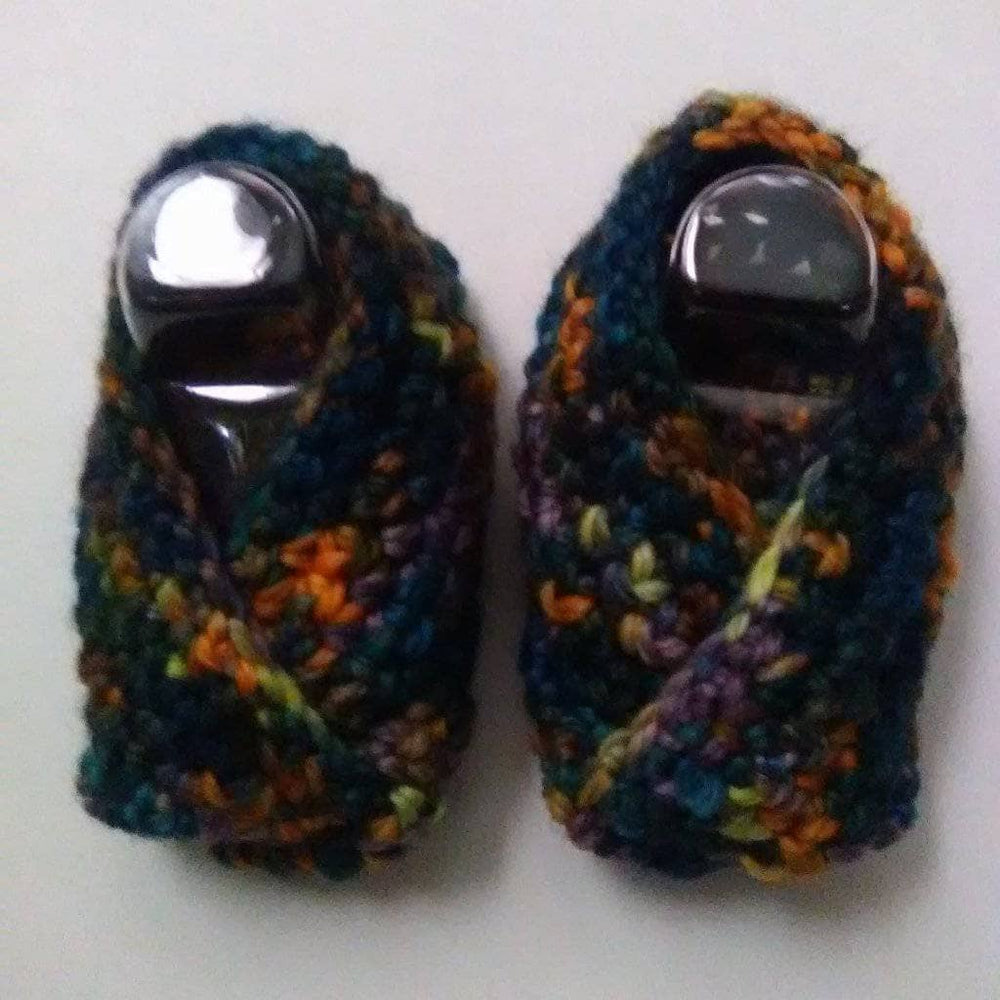 close up of two yarn shoes over a white background