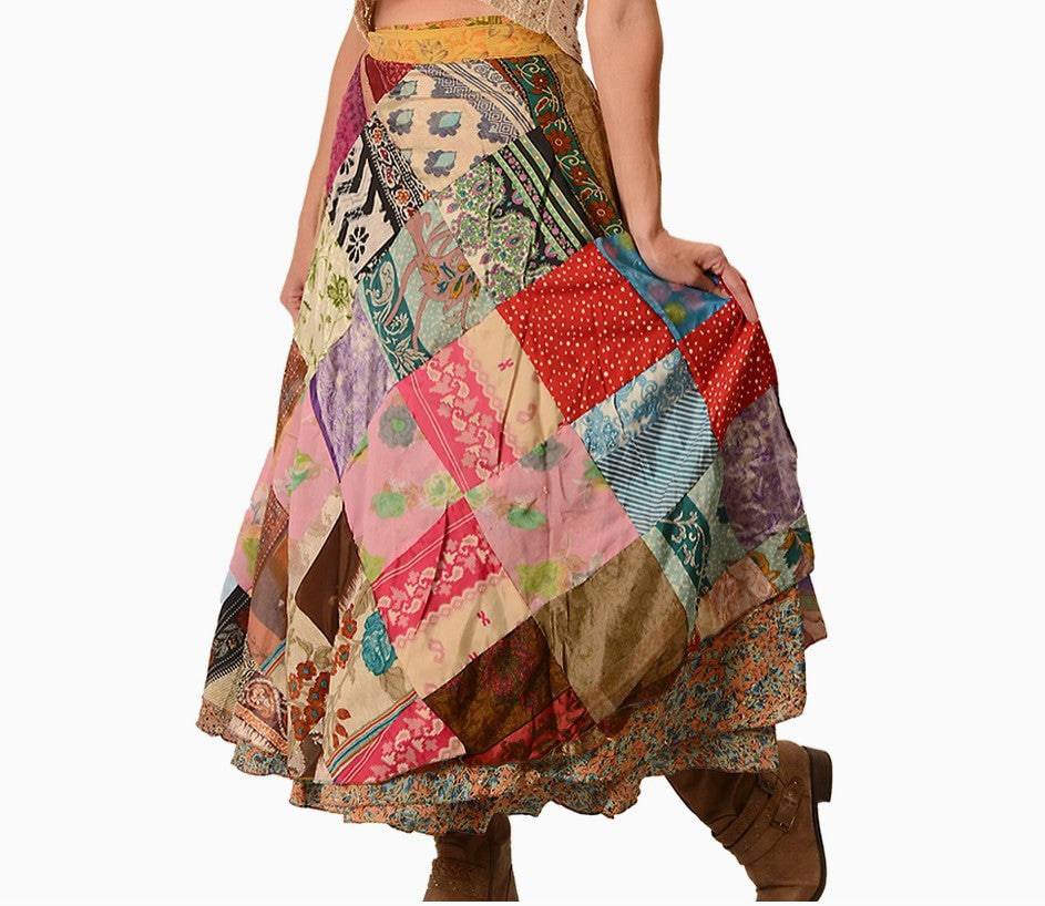 A person wearing a colorful patchwork skirt with various patterns and colors, including floral, stripes, and polka dots. The skirt is paired with brown boots.